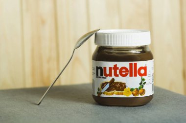 Kyiv, Ukrayna - 5 Ağustos 2017 Nutella Fındık kavanozu. Fındıklı kavanoz açıldı. Tahta arka planda Nutella ve kaşık.