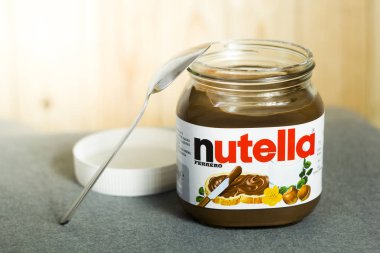 Kyiv, Ukrayna - 5 Ağustos 2017 Nutella Fındık kavanozu. Fındıklı kavanoz açıldı. Tahta arka planda Nutella ve kaşık.