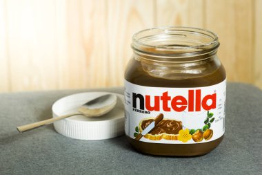 Kyiv, Ukrayna - 5 Ağustos 2017 Nutella Fındık kavanozu. Fındıklı kavanoz açıldı. Tahta arka planda Nutella ve kaşık.