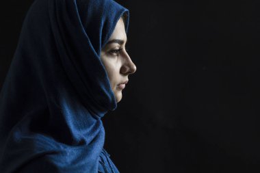 Siyah bir arka plan profil yüzüne hüzünlü Müslüman kız.