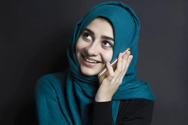 快乐的穆斯林女孩在电话里聊天 一个年轻的阿拉伯女人用智能手机交流 — 图库照片