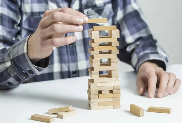 Man, engineer, Building Up Tower, Challenge In Business Concept. Tower Game with a Wooden.