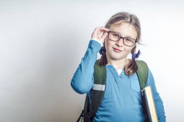 Kız, kız öğrenci ile gözlük ve kameraya bakarak gülen sırt çantası ile.