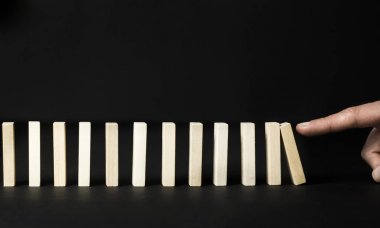 Siyah bir arka plan üzerinde domino etkisi. İlk bölümü aşağıdaki düşüyor. 