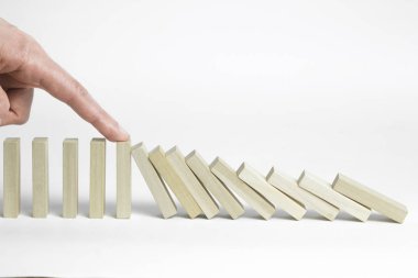 Domino etkisi etkisini durdurmak. Parmak düşen tahta bloklar durdurur. İşletme Yönetimi ve geliştirme kavramı.