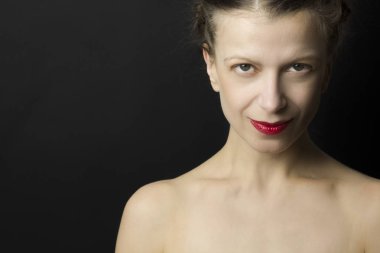 Siyah bir arka plan üzerinde başarılı, maksatlı, kendine güvenen, çekici bir kadın portresi. Kopya alanı