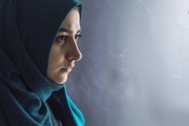 Üzgün Müslüman kız hijab siyah bir arka plan. Profil, kopya alanı Arap genç kadın yüzüne. 