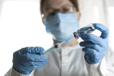 Bir doktorun elinde enjeksiyon için şırınga. Aşı.