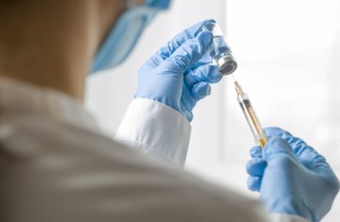 Bir doktorun elinde enjeksiyon için şırınga. Aşı.