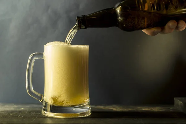 新鮮なビールは ジョッキに瓶から注がれています 黒の背景に低アルコール飲料のガラス — ストック写真