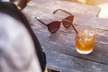 Ahşap bir masa üzerinde bir buz boru ile alkollü bir kokteyl bardak. Yaz sıcağında soğuk içecek.