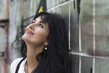 Güzel bir mutlu genç esmer kadın portresi. Neşeli kadın ararken gülümseyen.  