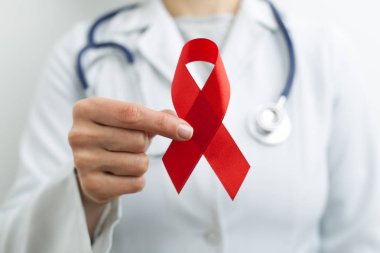 Dünya Yardım Günü 'nün sembolü olarak bir doktorun elinde kırmızı kurdele..