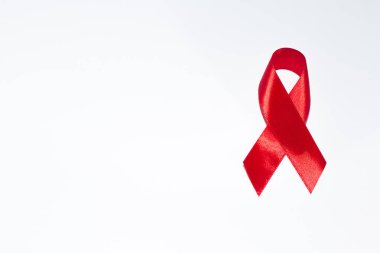 İzole edilmiş beyaz arka planda kırmızı kurdele Dünya AIDS Günü 'nün sembolüdür..