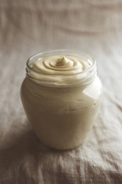 Cam bir kavanozda mayonez. Yaklaş. Ekşi krema.