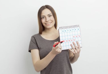 Kadının elinde belirli günleri olan bir takvim var. Adet dönemi konsepti.