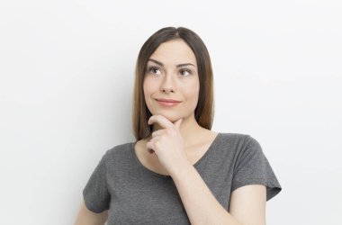 Beyaz arka planda dalgın genç bir kadın. Bir kız bir fikir düşünüyor..