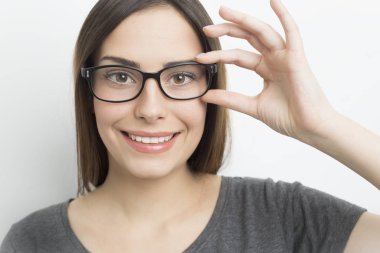 Smiling young woman in glasses on a white background. 