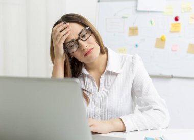Bilgisayarın başında yorgun bir kadın var. Baş ağrısı. 
