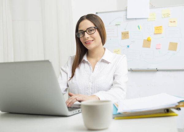 Portrait of a smiling woman financier working at a computer. 