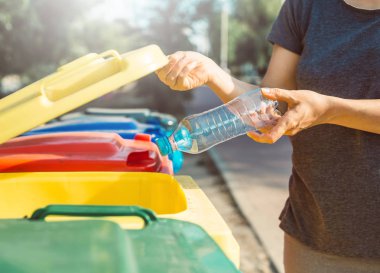 Plastik bir şişe bir çöp kutusuna atılır. Çöp konteynırını ayır. Çevre kirliliğini kavra.