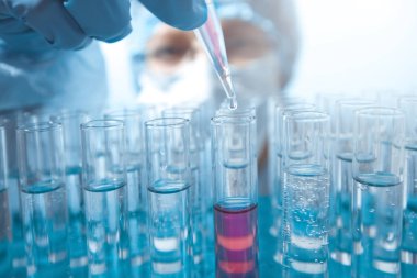 Coronavirus aşısı. Bir damla pipetten bir test tüpüne damlıyor. Laboratuvar araştırması.