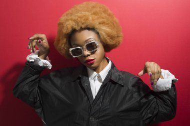 Kıvırcık saçlı Afro-Amerikan bir kadının portresi. Temiz tenli, modaya uygun siyah bir kız..