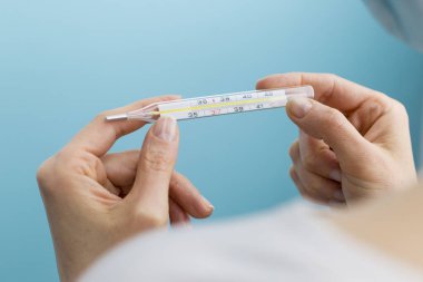 Kadının elinde termometre var. Viral hastalıklar kavramı.