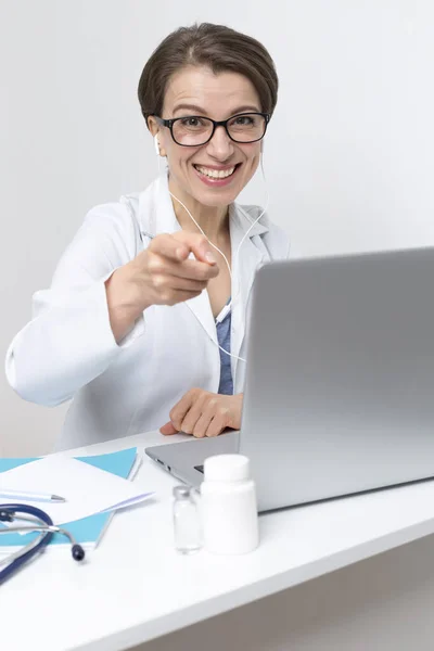一个微笑的女医生在电脑屏幕上通过视频通话给病人建议的肖像 医生在会议上与客户进行了电话联系 并在手提电脑上进行了交谈 — 图库照片