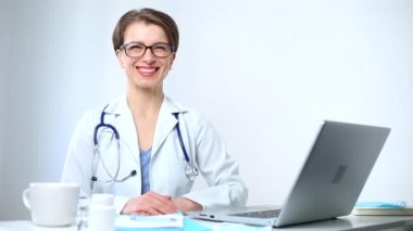 İş yerinde oturan gülümseyen bir kadın doktorun portresi..