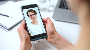 Akıllı telefondan görüntülü arama. Cep telefonuyla konuşan bir kadın.. 