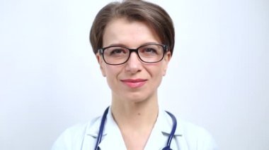 Gülümseyen bir kadın doktorun portresi. Yüze yakın çekim.