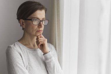 Pencerenin yanında dalgın genç bir kadının portresi.