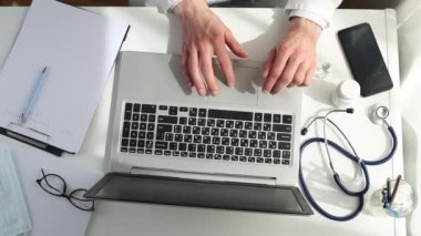 Masa başında çalışan bir doktorun elleri. Üst görünüm.