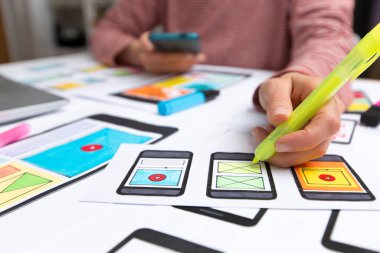 Tasarımcılar web sitesi uygulamaları geliştirirler. Tasarımcılar arayüzün taslaklarını çizerler. Kullanıcı deneyimi kavramı.