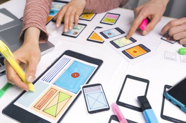 Tasarımcılar web sitesi uygulamaları geliştirirler. Tasarımcılar arayüzün taslaklarını çizerler. Kullanıcı deneyimi kavramı.