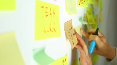 İş adamlarına beyin fırtınası yapmak yapışkan posta kağıtlarına fikir notları yazmak. Ekip ortak bir görev üzerinde çalışıyor. İş adamlarıyla tanışmak.