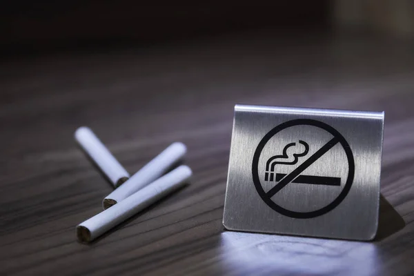 Немає знаку паління на дерев'яному столі. Концептуальна фотографія заборони на куріння в громадських місцях, медична, охорона здоров'я, безкоштовне куріння, небезпека і залежність . Стокове Зображення
