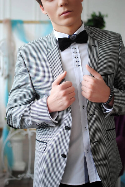 Stylish man. Stylish guy. Stylish wedding. Jacket and butterfly. White interior. Wedding arch. Wedding decorations. Male life style.