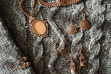Bir desen ile yünlü örme kazak üzerinde Bakır süsler. Bakır aksesuarlar.