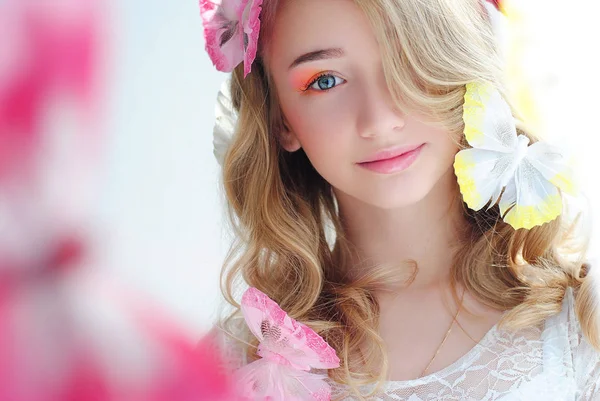 Bright makeup on the girl's face. Butterflies in the hair of a lady. Portrait of a gentle girl with a gentle make-up.