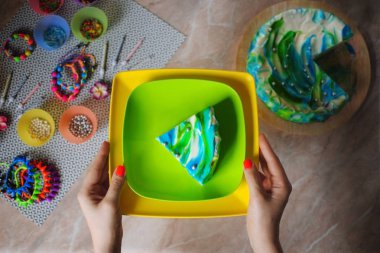 Doğum günü pastası. Festival kek. Kek üzerine bir tabak eller içinde. Kek üzerine mermer masa üstü görünümü.