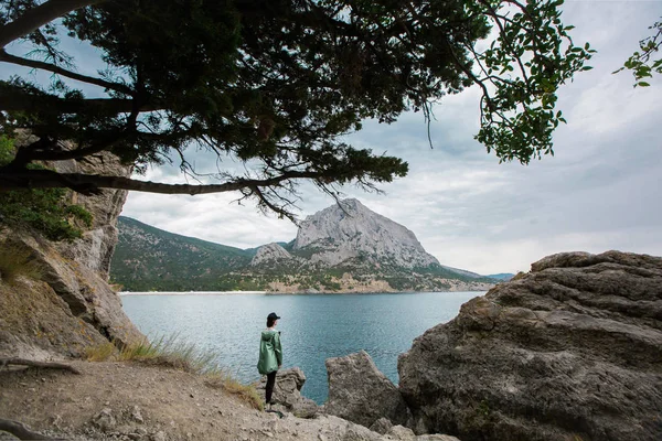 Kız dağın zirvesinde duruyor ve peyzaj fotoğraf çeker