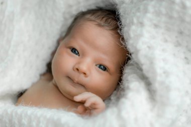 Yeni doğmuş bir bebek üzerinde beyaz ekose portresi.