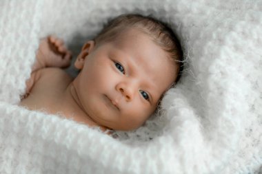 Yeni doğmuş bir bebek üzerinde beyaz ekose portresi.