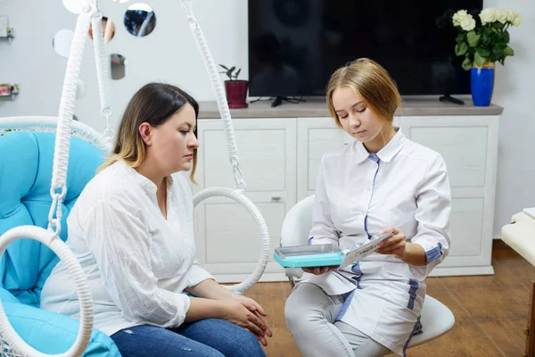 Woman visits young cosmetologist doctor. The doctor consults with the patient — Stock Photo, Image