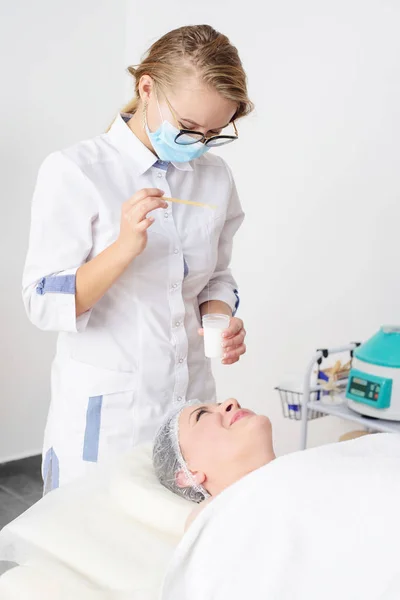 Cosmetóloga Joven Aplica Productos Cosméticos Cara Paciente Femenina Spa Procedimiento — Foto de Stock