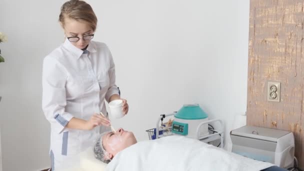 Young Female Cosmetologist Applies Cosmetic Product Face Female Patient Spa — Stock Video