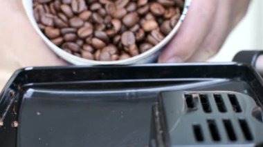 Kahve çekirdekleri kahve makinesine doluyor. Kapat.