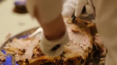 Aşçı bir bıçakla paylaşır yeni pişmiş büyük et bacağını kemiğe